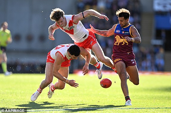 Tom McCartin (left) and Nick Blakey (centre) of the Swans collide while going for the ball against Callum Ah Chee (right) of the Lions during the AFL Round 19 match between the Brisbane Lions and the Sydney Swans at The Gabba in Brisbane, Sunday, July 21, 2024. (AAP Image/Darren England) NO ARCHIVING, EDITORIAL USE ONLY