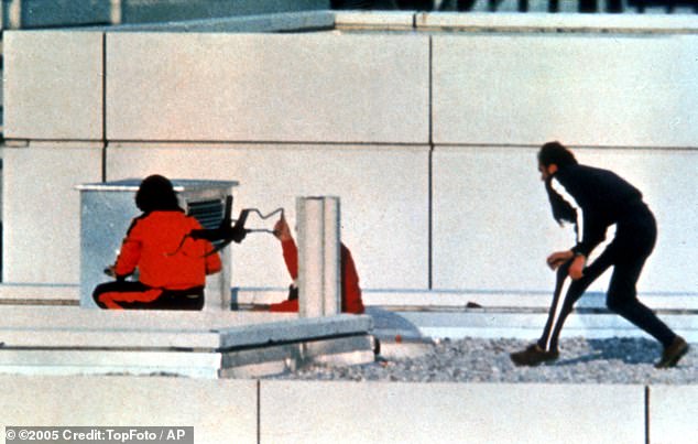 Two West German policemen wearing athleitic sweatsuits and armed with submachine guns get into position on the roof of the Munich Olympic village building where armed Arab gunmen hold Israeli Olympic team members hostage 6th September 1972