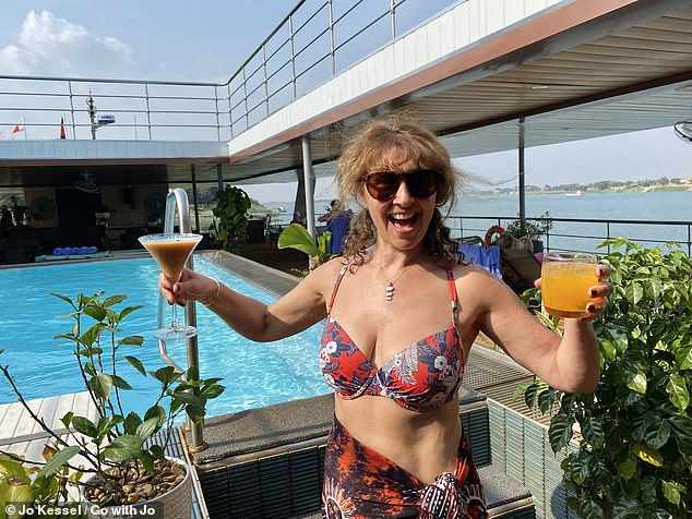 Jo is pictured here holding two of the ship's cocktails - the signature 'Rusty Nail' (right) and an espresso martini (left)