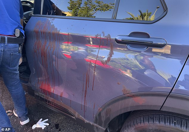 A police officer inspects a blood-stained car in which a hand-held pager exploded, in Beirut, Lebanon