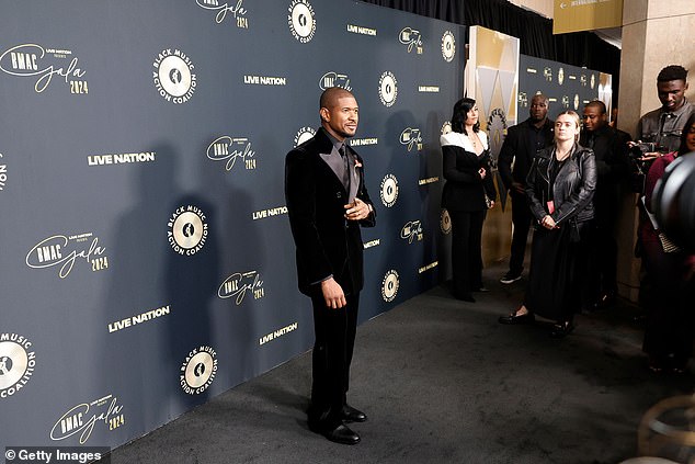 He wore a double-breasted jacket with wide, shiny peaked lapels, and he changed up the tux's look with a black shirt and a black necktie, instead of a traditional bow tie