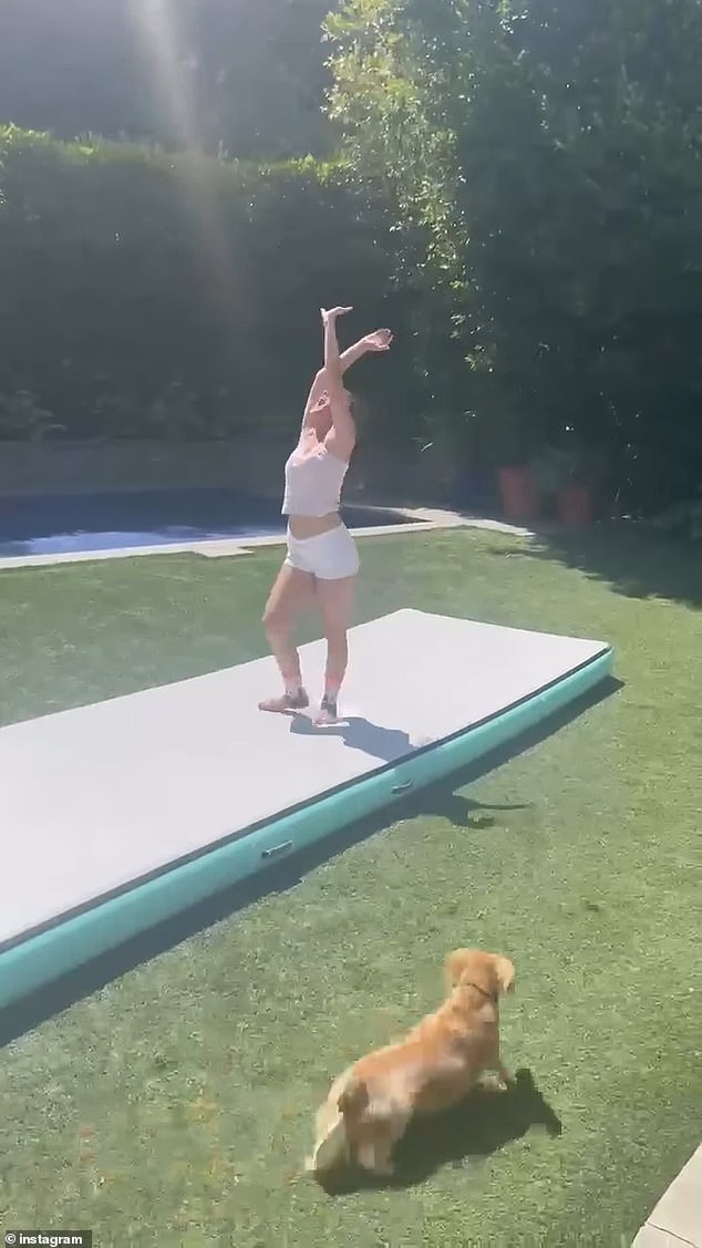 Charlotte, wearing white shorts and a yellow tank top, is seen proudly performing a cartwheel back-handspring for her mom