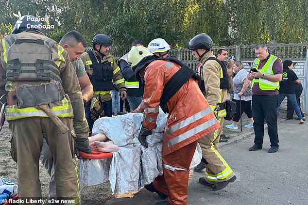 An elderly resident is stretchered out of the building, with 14 people injured in the blast