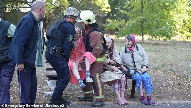 Elderly residents are assisted by emergency workers after the horror blast on the Sumy home