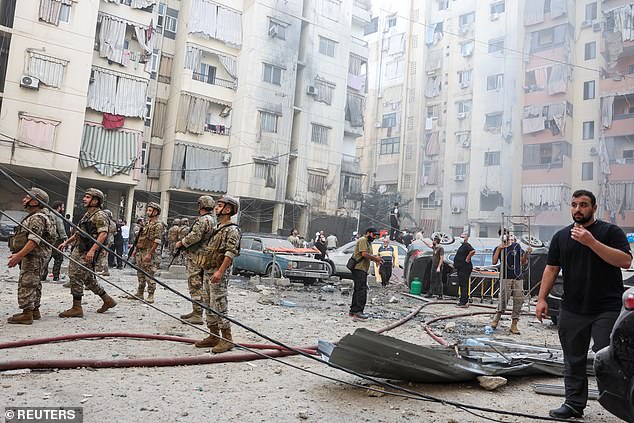 Residents and members of the military inspect the site of an Israeli strike in the southern suburbs of Beirut, Lebanon