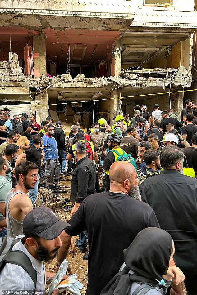 Residents and first responders gather at the scene of an Israeli strike in Beirut's southern suburbs on September 20, 2024