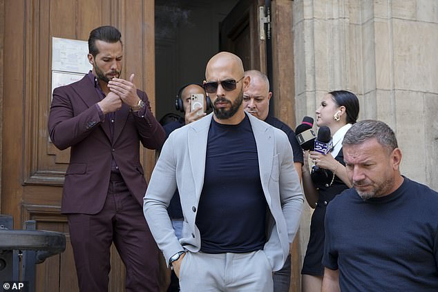 Andrew Tate, center, and his brother Tristan, left, walk outside the Court of Appeals building, after a hearing, in Bucharest, Romania