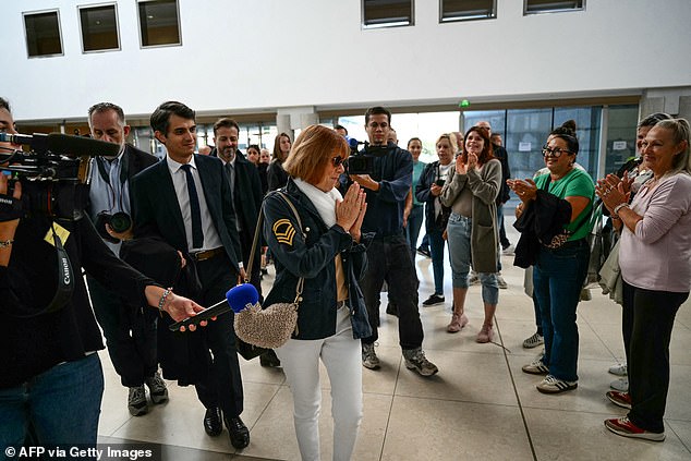 Gisele Pelicot (C) acknowledges applause by members of the public as she arrives at the courthouse of Avignon during the trial