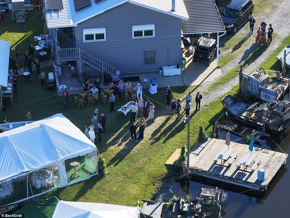 Wooden tables and stools were situated in the grass as guests mingled at the reception