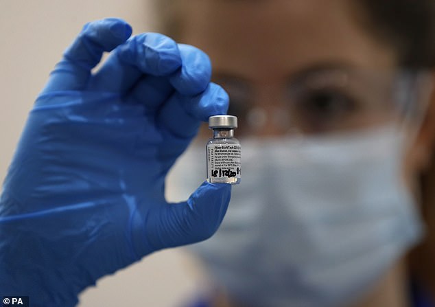 A nurse holds a phial of the Pfizer BioNTech Covid vaccine at Guy's Hospital in London as the immunisation programme begins in December 2020