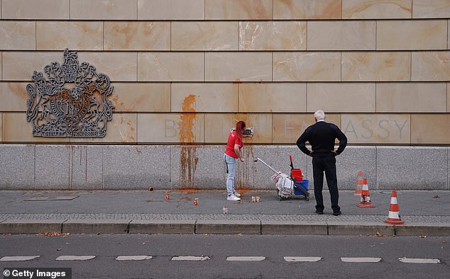 A worker cleans the facade of the British Embassy in Berlin, Germany, after soup was thrown over it