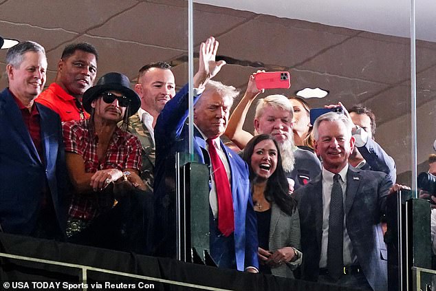 GOP Presidential candidate Donald Trump waves flanked by former Georgia Bulldogs player Herschel Walker, recording art Kid Rock, professional golfer John Daily, Alabama senators Tommy Tuberville (R) and Katie Britt (R) during the second half of the Georgia-Alabama game