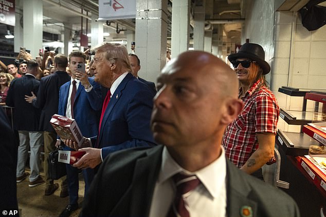 Trump and Kid Rock leave a concession stand during the Georgia-Alabama game