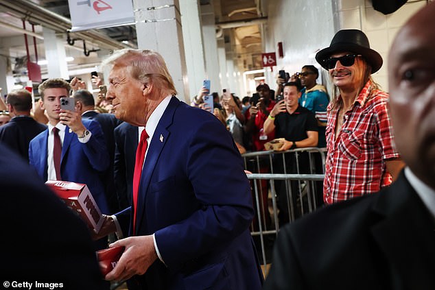 Trump and Kid ROck are seen smiling as they walk away from a concession stand