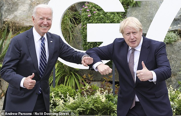 President Joe Biden and Mr Johnson pose next to the G7 sign