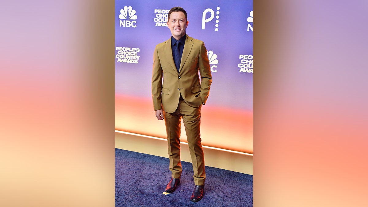 Scotty McCreery walked the red carpet at the 2024 People's Choice Country Awards red carpet in a brown suit.