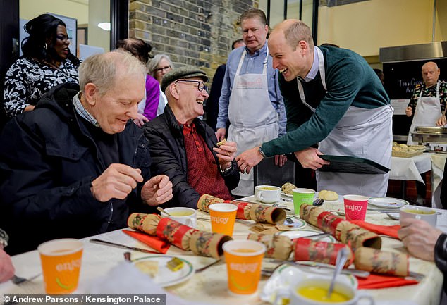 The royal shared a joke with one of the guests at the Christmas party while he dug into a pudding