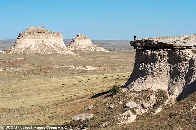 A person gazes out at the Pawnee Buttes, which are made of crumbling sandstone