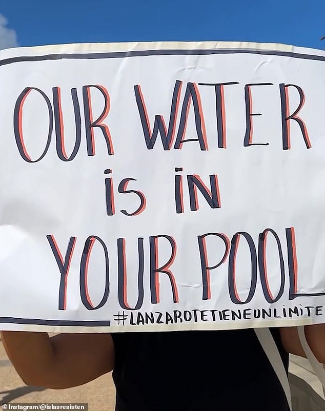 'Our Water is In Your Pool' slogan carried by a member of activist group 'Lanzarote Has a Limit'