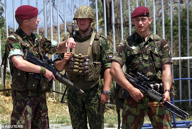 Later, British soldiers were seen with a Russian paratrooper (centre) guarding the airport