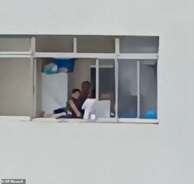 The woman was eventually rescued as people down below the building clapped