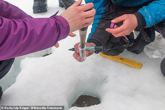 The Martian life that may one day be found in the Red Planet's dusty ice might resemble life in ' 'cryoconite holes' here on Earth. Above, researchers sample a cryoconite hole on the Longyearbreen glacier, somewhere along Norway's Svalbard archipelago in 2017