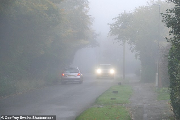 OXFORDSHIRE: Vehicles drive along a foggy country lane in the village of Dunsden today