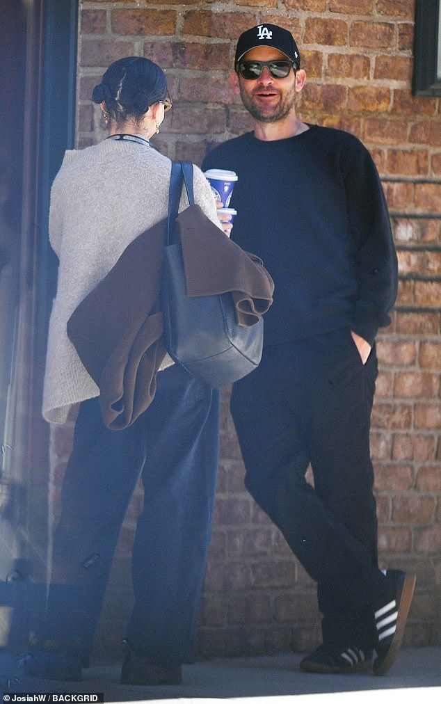 Kravitz wore loose-fitting indigo blue jeans with a light gray cardigan and black boots while Tobey was clad in black trousers, black and white Adidas sneakers