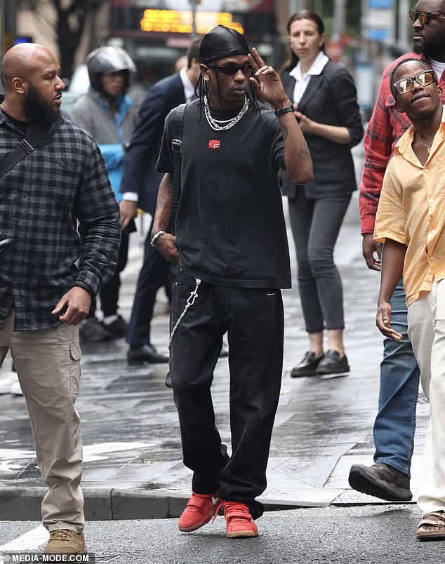 For the outing, Travis cut a laidback figure in a black T-shirt and baggy trousers as he was spotted greeting fans