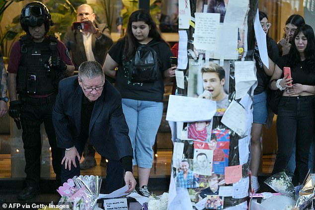 Geoff Payne (left), the father of One Direction pop singer Liam Payne, looks at the place where fans paid tribute to his late son outside the CasaSur Hotel