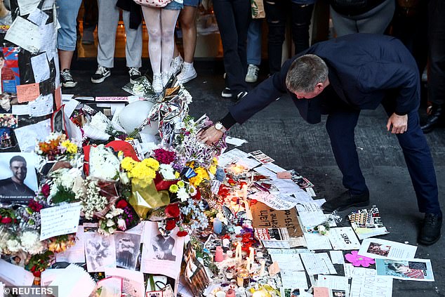 Geoff Payne (right) visits a memorial outside the Casa Sur Hotel where the British pop singer fell to his death