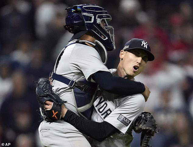 Catcher Austin Wells jumps into the arms of closer Luke Weaver after the last out of the ALCS