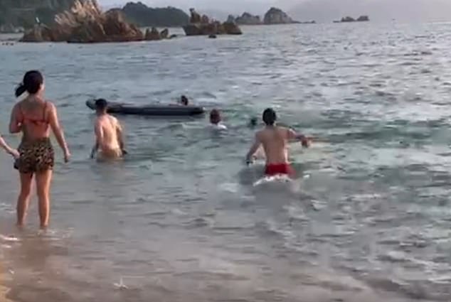 Bystanders can be heard shouting in a panic, with one person throwing a paddle board towards the man to bring him to safety