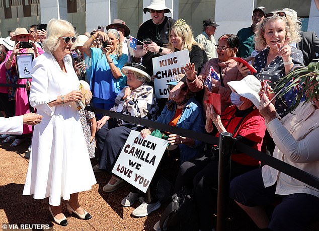 Matching her white dress with a pair of light grey sunglasses and beige heels, she met her fans