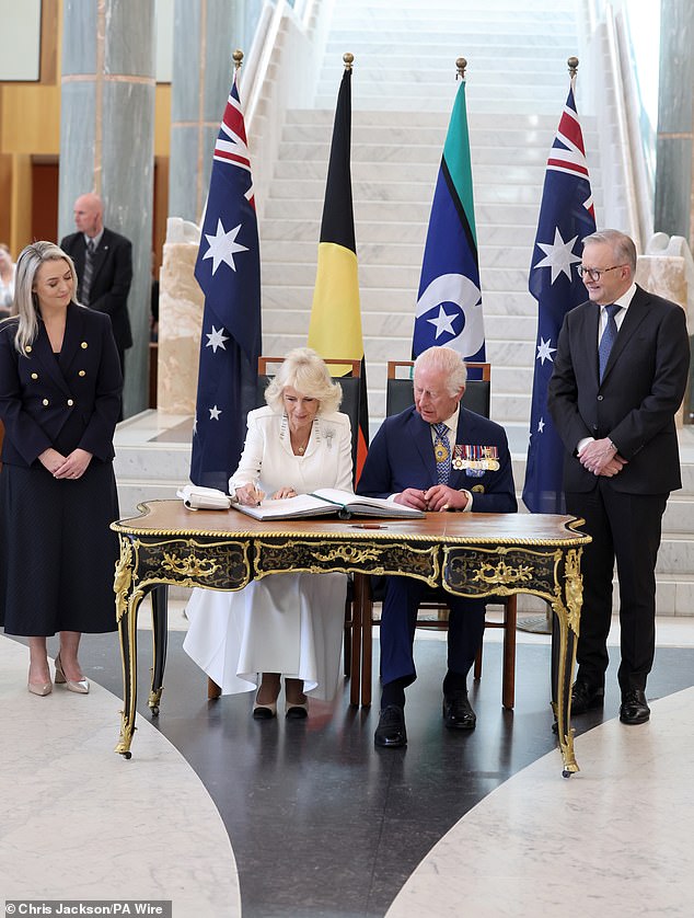 King Charles III and Queen Camilla sign the visitors book during the ceremonial welcome to Australia at Australian Parliament House in Canberra