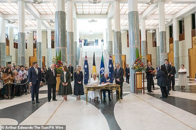 King Charles III and Queen Camilla sign the visitors book during the Ceremonial Welcome to Australia at Australian Parliament House in Canberra today