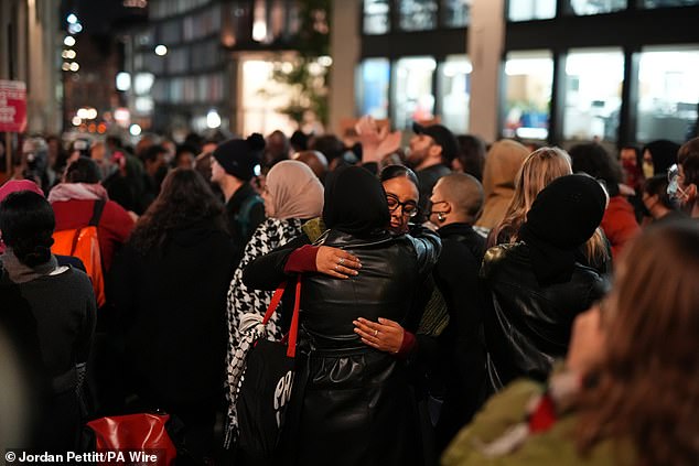 Emotional protesters hug each other during the demonstration after Mr Kaba's killer was cleared