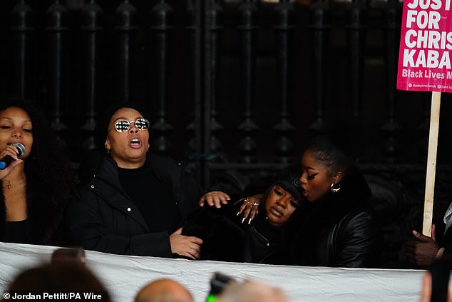 Temi Mawale (left), Kayza Rose (second left) and Sheeda Queen (second right, cousin) demonstrate outside the Old Bailey in central London tonight