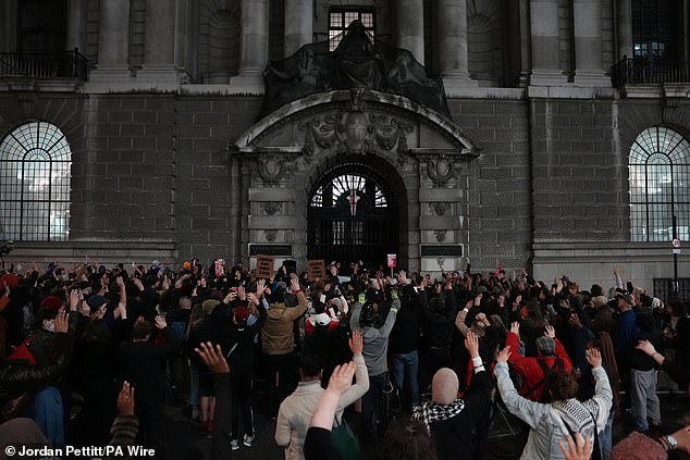 Hundreds gather outside the entrance to the Old Bailey court in central London this evening