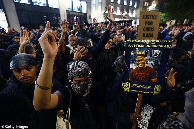 Some signs have Mr Kaba's face on them at tonight's protest in central London