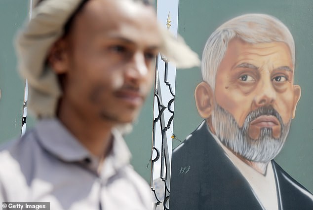 A Yemeni man looks at an artwork depicting the Hamas' Political Bureau Head Yahya Sinwar