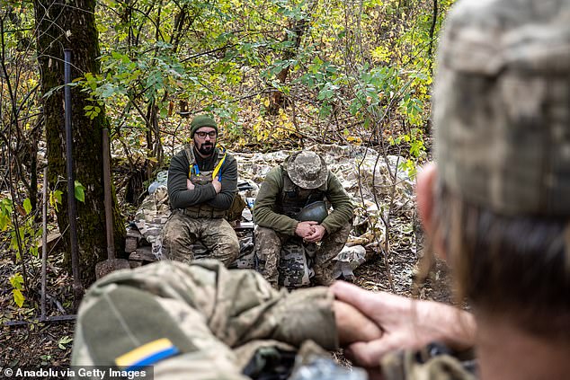 A group of Ukrainian soldiers rest after firing a howitzer on Russian positions in Donetsk Oblast, Ukraine on October 21, 2024