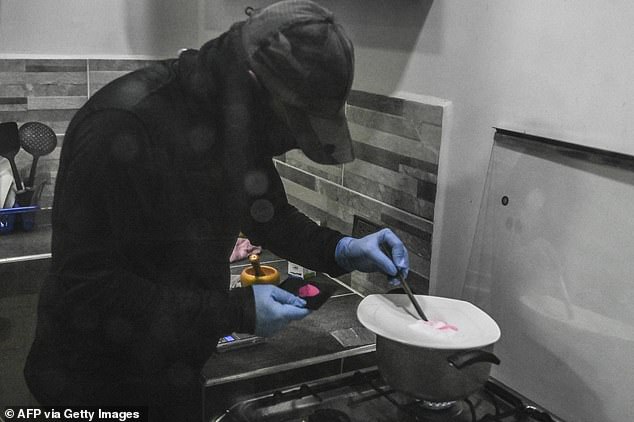 Such a surge has come alongside a number of tragic deaths, with experts telling MailOnline the drug was 'very dangerous and unpredictable' as the recipe varies so much. Pictured a man preparing pink cocaine by mixing the ingridients