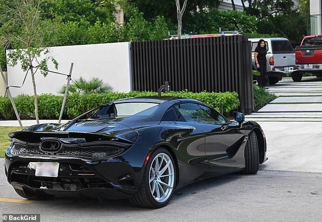 Beckham is spotted arriving to inspect his newly-purchased home in a McLaren supercar