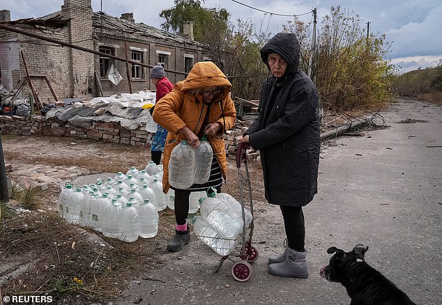 Residents take bottles with drinking water from humanitarian aid delivered by volunteers, in the course of Russia-Ukraine conflict, in the front line city of Chasiv Yar in Donetsk region, Ukraine October 16, 2024