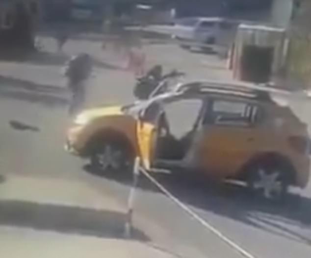 The attackers are seen by an abandoned car near the entrance of the defence manufacturer building