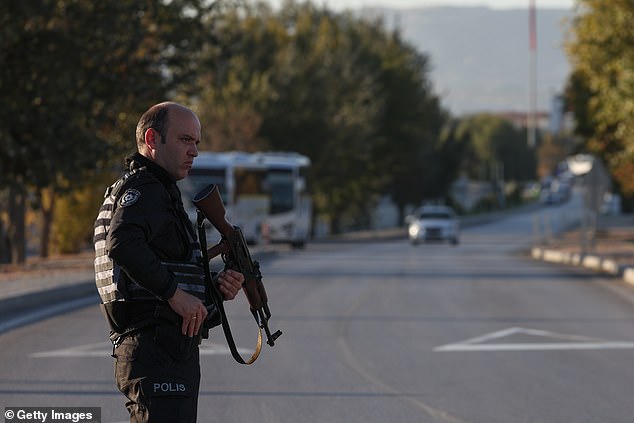 Police stand guard at the road leading to the Turkish Aerospace Industries facility following the attack