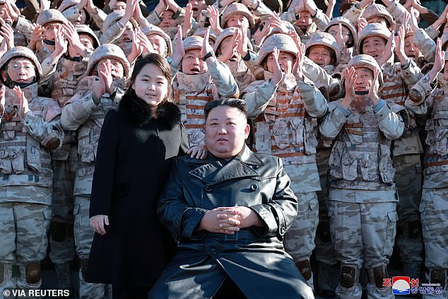 North Korean leader Kim Jong Un and his daughter attend a photo session with the scientists, engineers, military officials and others involved in the test-fire of the country's new Hwasong-17 intercontinental ballistic missile (ICBM)