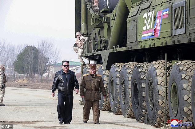 North Korean leader Kim Jong Un, center left, walks around  Hwasong-17 intercontinental ballistic missile (ICBM) with one of his military chiefs