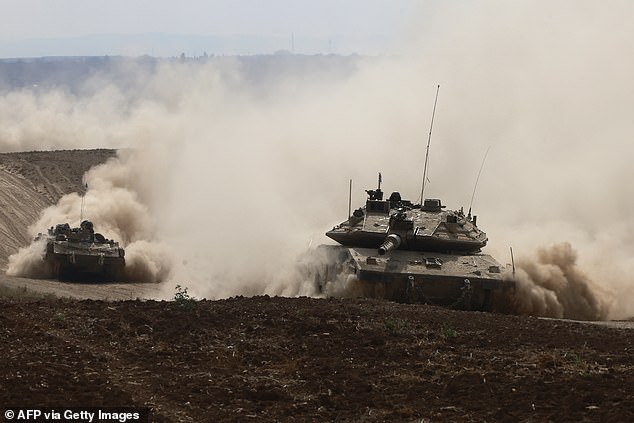 Israeli tanks drive in an area near Israel's southern border with the Gaza Strip on October 6